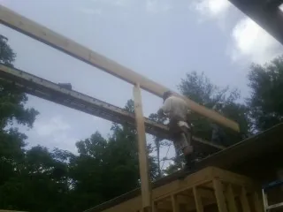 Carpenter setting a ridge beam over a new addition frame — Ice Dam Removal by Roofing Brothers in Lenhartsville