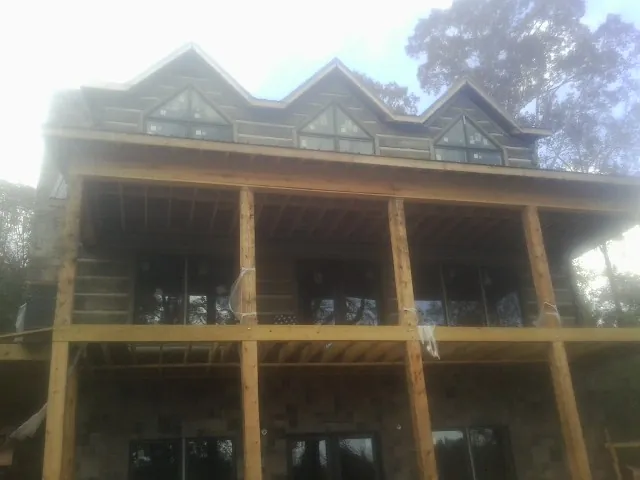 Dormers and porch framing on a large log home under construction — Roof Coating work by our crew in Lenhartsville